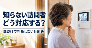 高齢の親が玄関を開けず、室内のカメラ付きインターホンで知らない訪問者を確認している様子